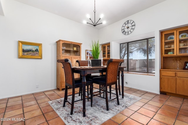 dining area with a chandelier, baseboards, and light tile patterned floors