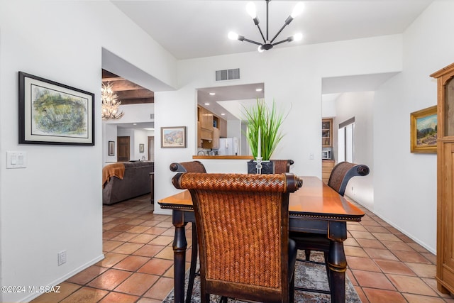 dining space with a chandelier, baseboards, visible vents, and tile patterned floors