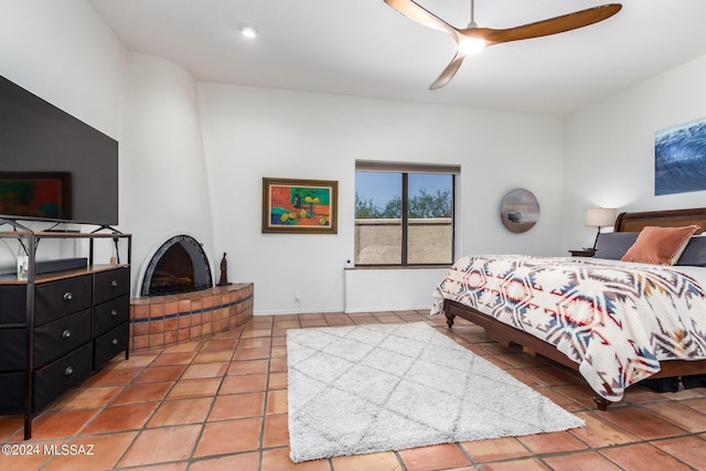 tiled bedroom with a fireplace and ceiling fan