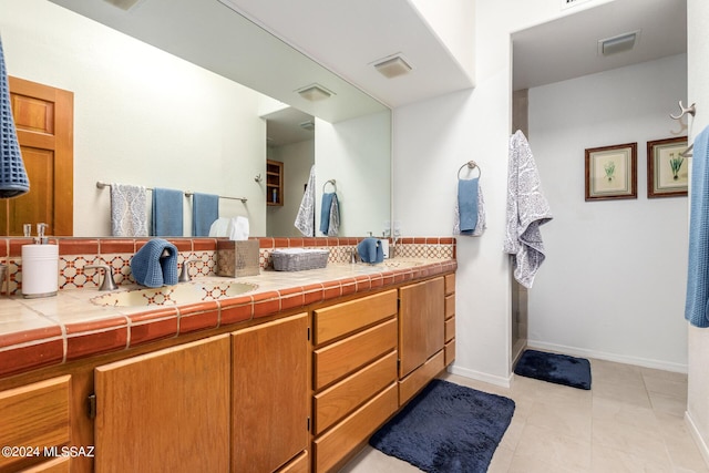 bathroom with tasteful backsplash, tile patterned floors, visible vents, and double vanity