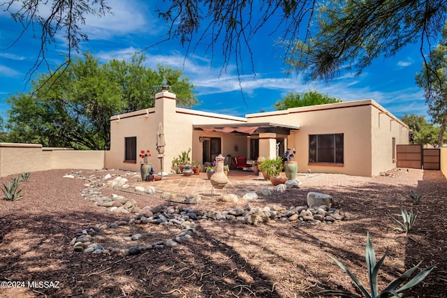 rear view of house with a patio, a chimney, a fenced backyard, and stucco siding