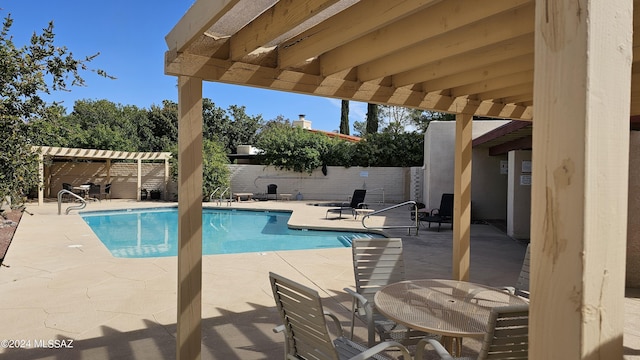 community pool with a patio area, a fenced backyard, and a pergola