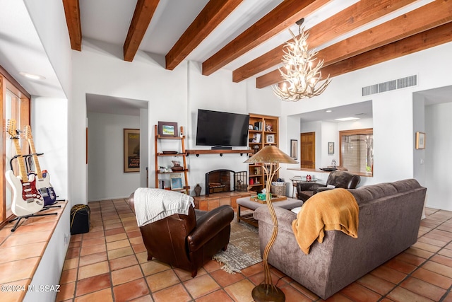 living room with a fireplace with raised hearth, light tile patterned floors, a notable chandelier, visible vents, and beamed ceiling