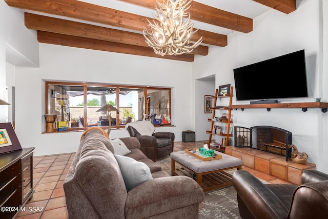 living room featuring a tile fireplace, beam ceiling, light tile patterned flooring, and an inviting chandelier