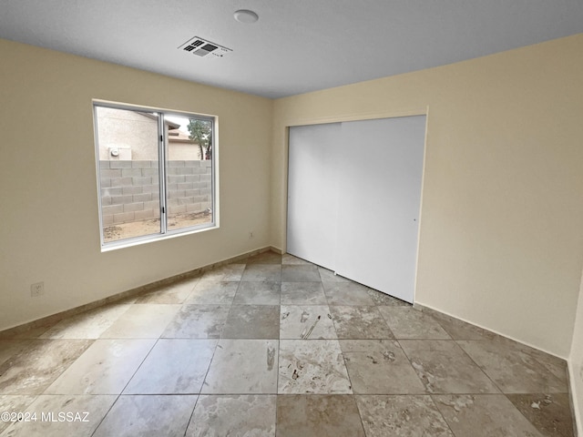 unfurnished bedroom with a closet and visible vents