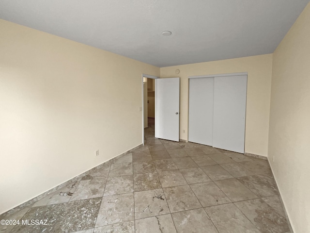 unfurnished bedroom with a closet and baseboards