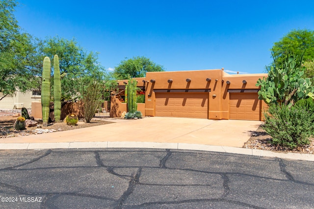 pueblo revival-style home featuring a garage