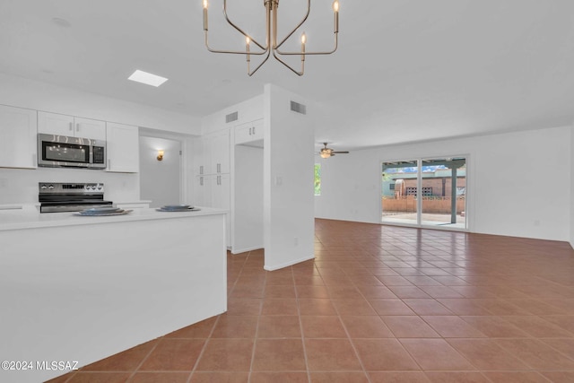 kitchen with tile patterned flooring, visible vents, open floor plan, stainless steel appliances, and white cabinetry