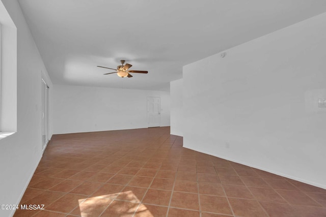 tiled empty room featuring a ceiling fan