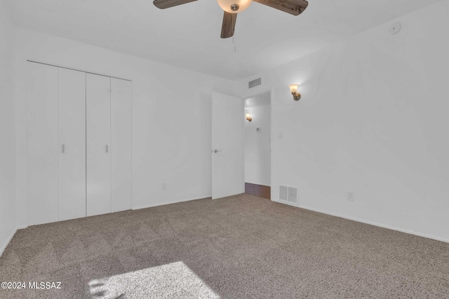 unfurnished bedroom with carpet flooring, visible vents, a closet, and ceiling fan