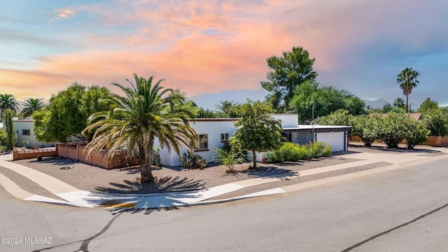 view of front facade with concrete driveway, an attached garage, and stucco siding