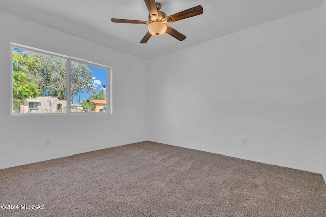 carpeted empty room with a ceiling fan