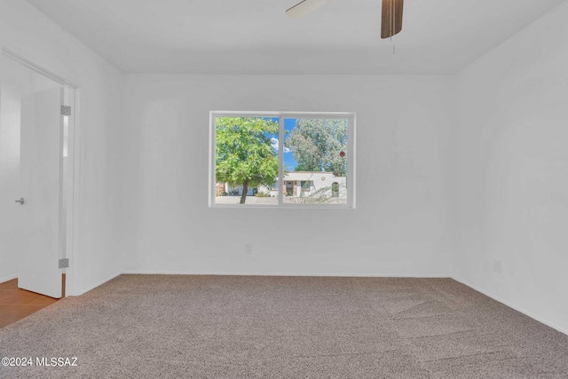 empty room featuring a ceiling fan and carpet flooring