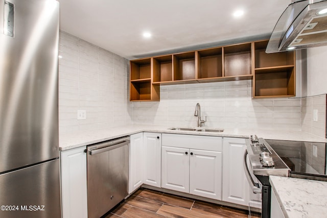 kitchen with sink, light stone countertops, dark hardwood / wood-style floors, appliances with stainless steel finishes, and white cabinets