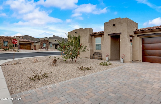 adobe home featuring a tiled roof and stucco siding