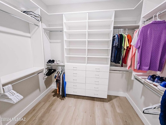 walk in closet with wood finished floors