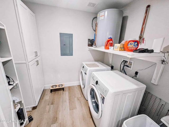 clothes washing area featuring light wood-style flooring, water heater, cabinet space, electric panel, and washer and clothes dryer