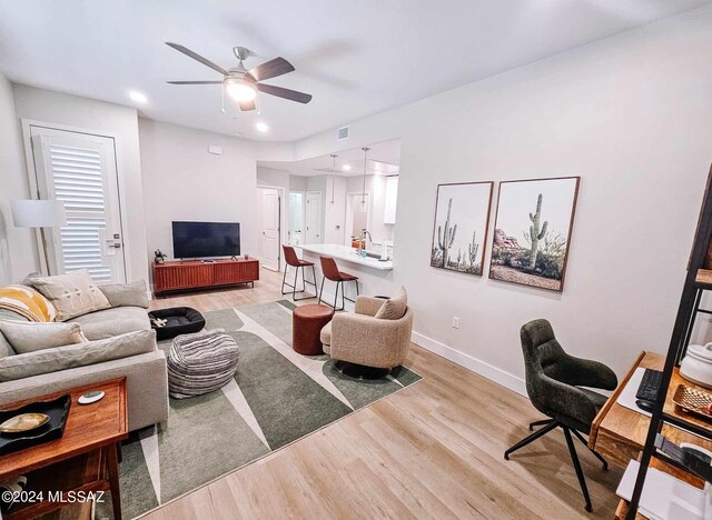 living room with hardwood / wood-style floors and ceiling fan