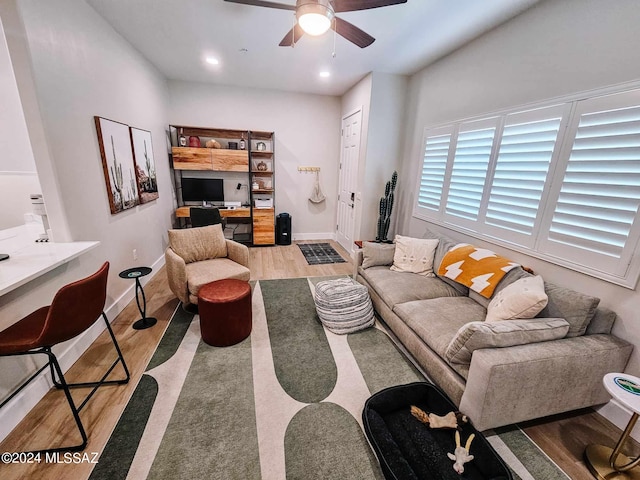 living area featuring baseboards, built in study area, ceiling fan, wood finished floors, and recessed lighting