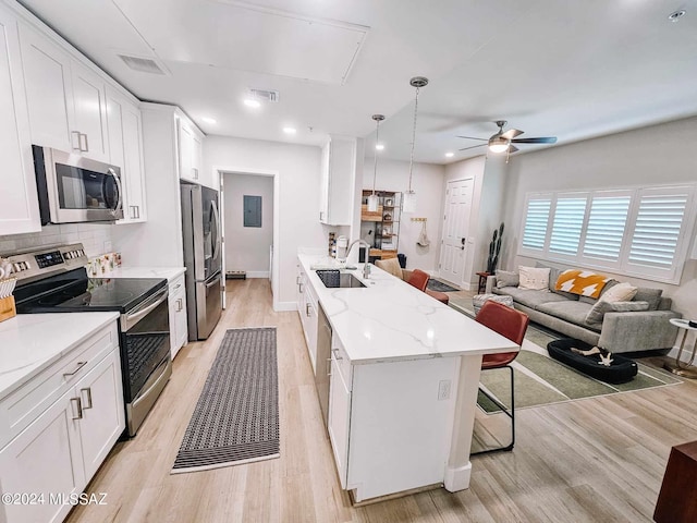 kitchen with a breakfast bar area, visible vents, appliances with stainless steel finishes, white cabinetry, and a sink