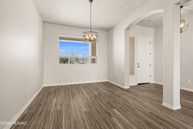 unfurnished room with dark hardwood / wood-style flooring and an inviting chandelier