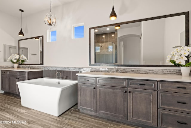 bathroom with plus walk in shower, hardwood / wood-style floors, vanity, and decorative backsplash