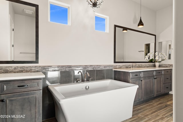 bathroom with hardwood / wood-style floors, vanity, tile walls, and a tub