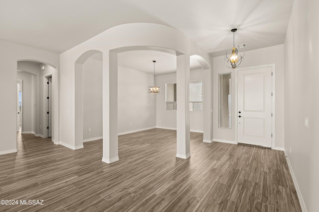 entryway featuring dark hardwood / wood-style flooring and an inviting chandelier