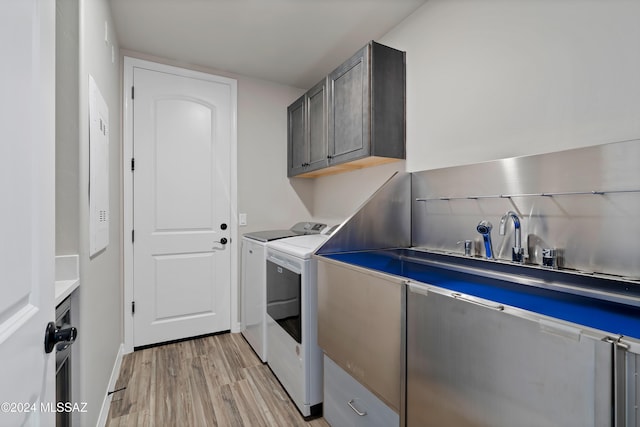 washroom featuring cabinets, light hardwood / wood-style floors, and washer and dryer