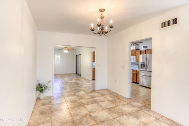 spare room with ceiling fan with notable chandelier and light tile patterned floors