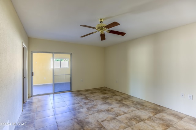 tiled spare room featuring ceiling fan