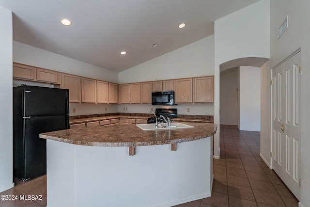 kitchen with sink, black appliances, light brown cabinets, high vaulted ceiling, and a center island with sink