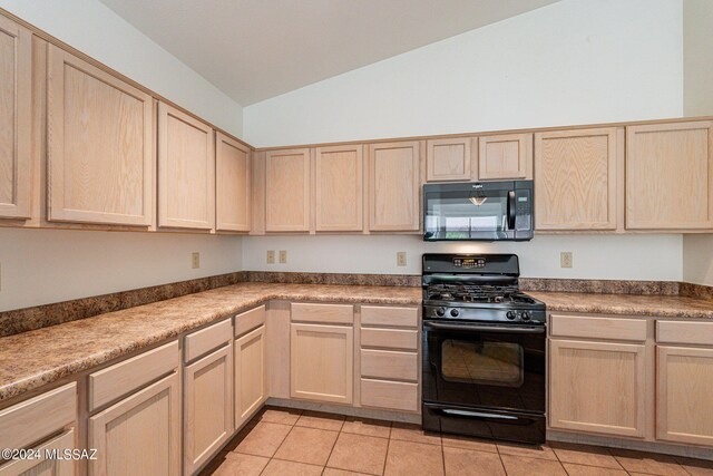 kitchen featuring lofted ceiling, black appliances, and light brown cabinetry