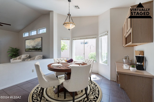 dining area with vaulted ceiling, plenty of natural light, dark tile patterned flooring, and ceiling fan