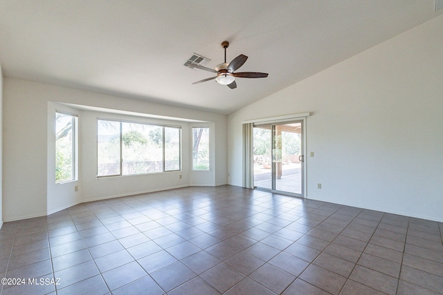 spare room featuring lofted ceiling, plenty of natural light, light tile patterned floors, and ceiling fan