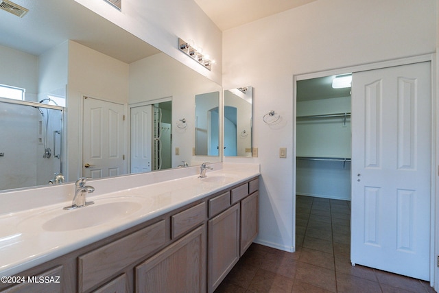 bathroom with tile patterned floors, vanity, and a shower with shower door