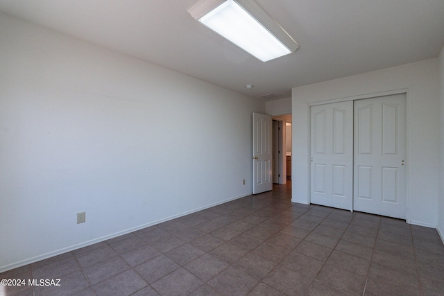 unfurnished bedroom featuring tile patterned flooring and a closet