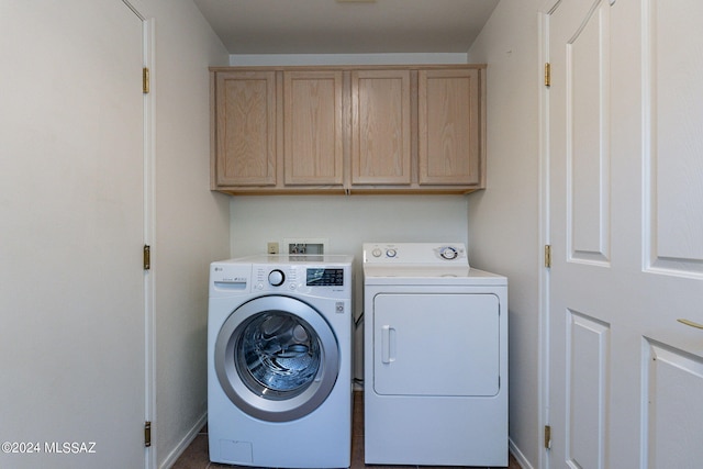 clothes washing area featuring washing machine and clothes dryer and cabinets