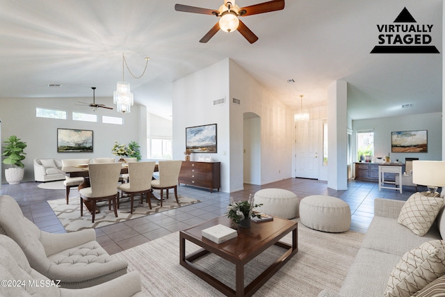 tiled living room with lofted ceiling and ceiling fan