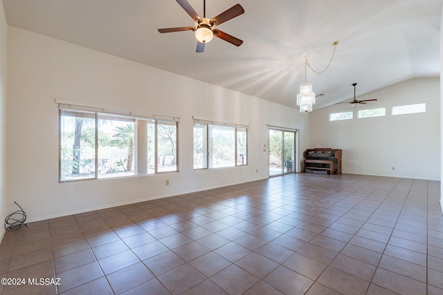 unfurnished living room featuring tile patterned flooring, ceiling fan with notable chandelier, and high vaulted ceiling