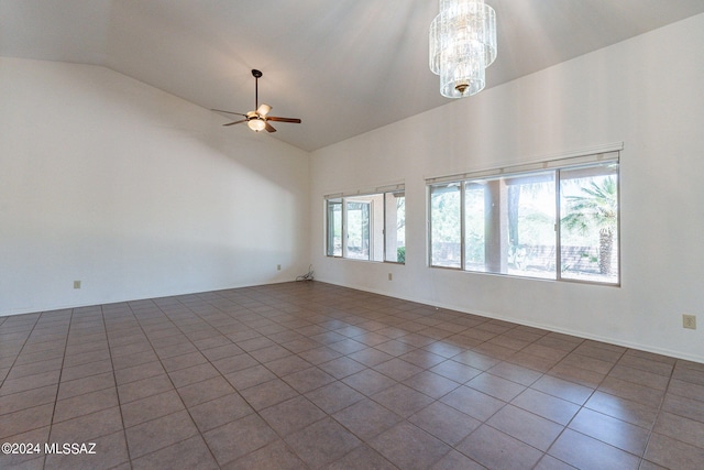 empty room featuring lofted ceiling, ceiling fan with notable chandelier, and tile patterned floors