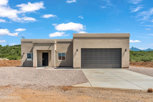 adobe home featuring a mountain view and a garage