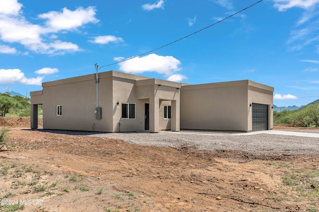 view of front facade with stucco siding, driveway, and an attached garage