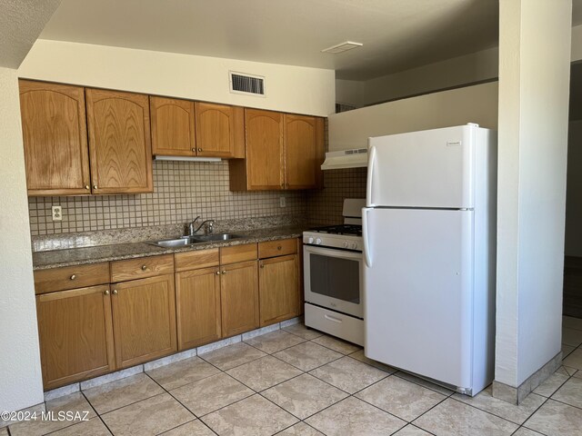 kitchen featuring range hood, light tile patterned floors, white appliances, sink, and decorative backsplash