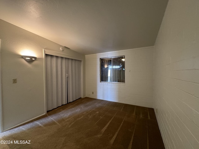 unfurnished room with carpet flooring and lofted ceiling