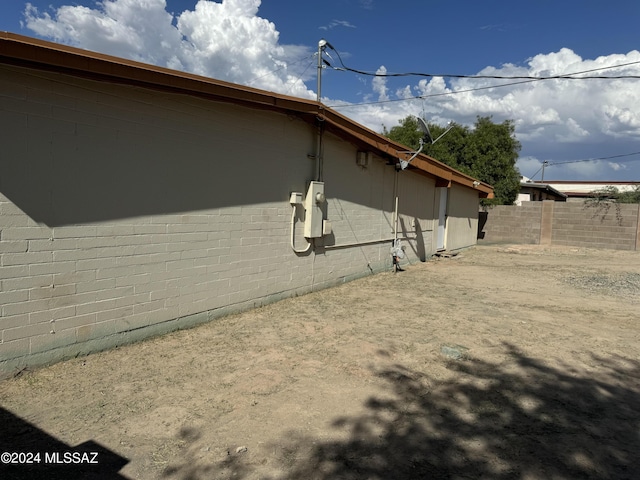 view of home's exterior featuring fence and brick siding