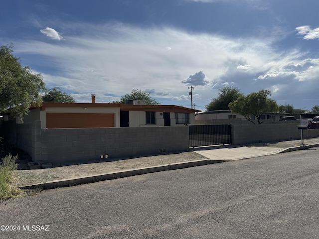 ranch-style house featuring fence and a gate