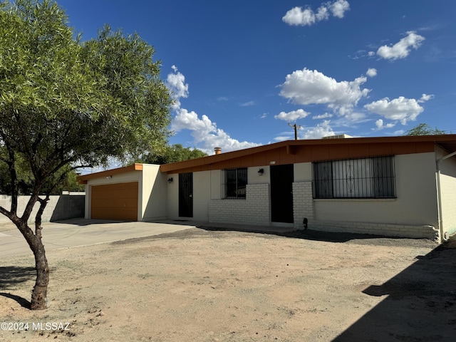 ranch-style house featuring brick siding, a garage, and driveway