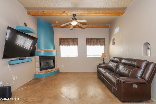 living room with ceiling fan, beam ceiling, and a fireplace