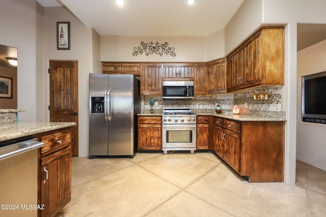 kitchen with backsplash, stainless steel appliances, and light stone countertops